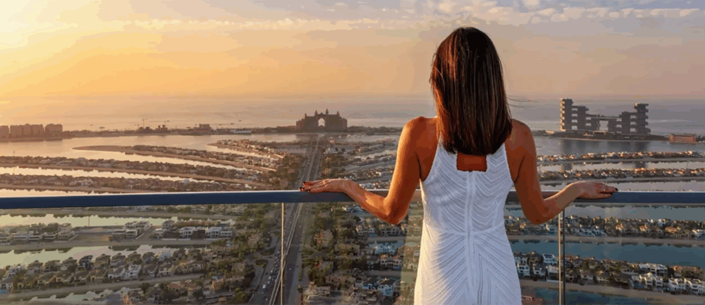 Woman standing on balcony of her first home in Daubai -Feautured image