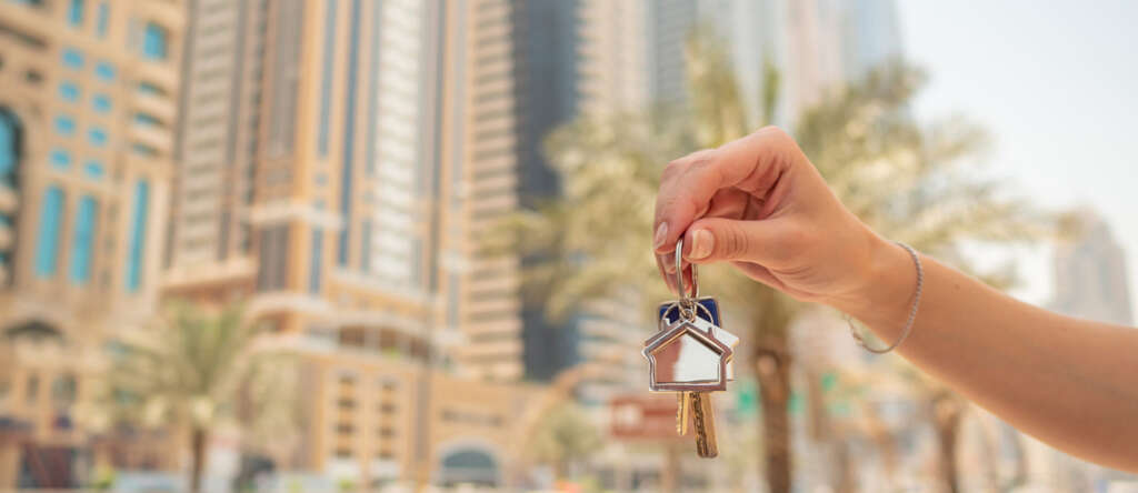 Hand girl holds the keys. The concept of buying an apartment or car in Dubai. Hand close-up.